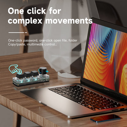 3-key mini keyboard used for custom shortcuts beside a laptop